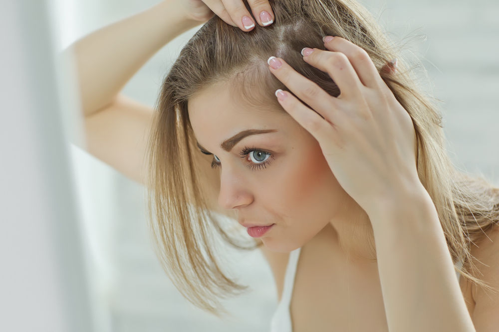 Woman inspecting her scalp