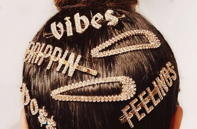 A woman with her hair in a top knot with bejeweled clips in her hair
